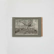 A monochrome landscape sketch of trees and forest floor, mounted on a light gray backing with a brown paper edge, photographed against a plain white background.