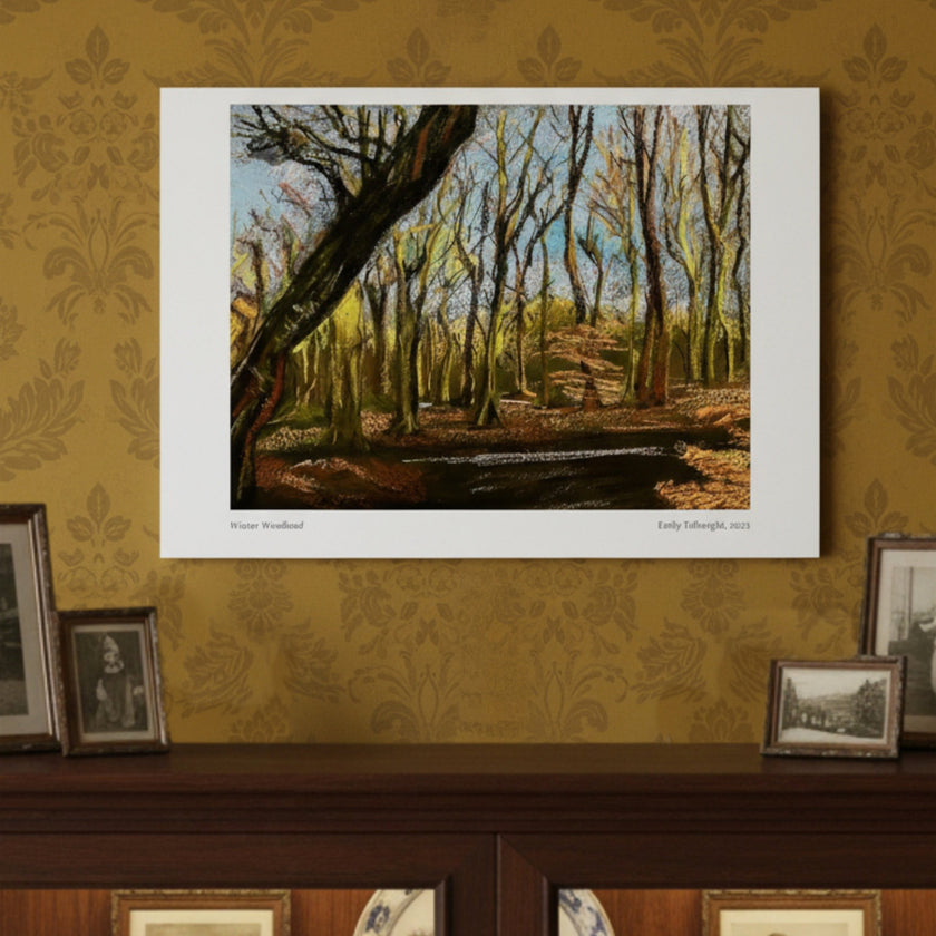 An art print depicting a woodland scene with bare trees and a path, mounted on a patterned gold wallpaper wall above a dark wooden mantel with other framed pictures.