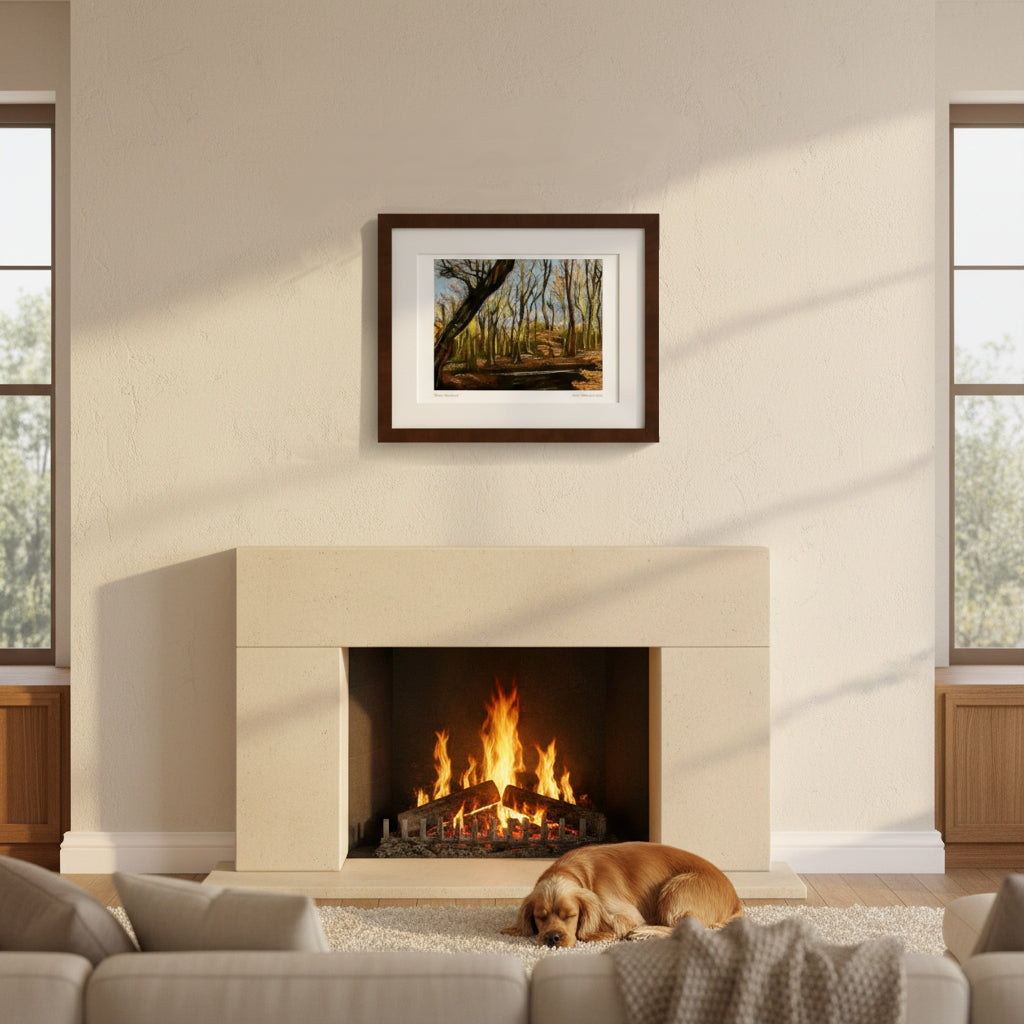 A framed forest landscape art print hangs above a fireplace in a modern living room setting with a dog sleeping on the rug below.