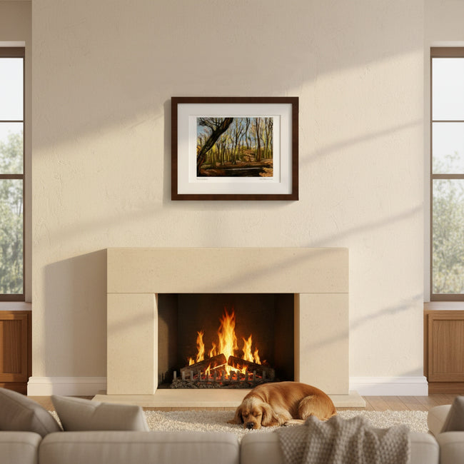 A framed forest landscape art print hangs above a fireplace in a modern living room setting with a dog sleeping on the rug below.