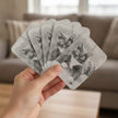Edith the cat playing cards fanned in someone's hand