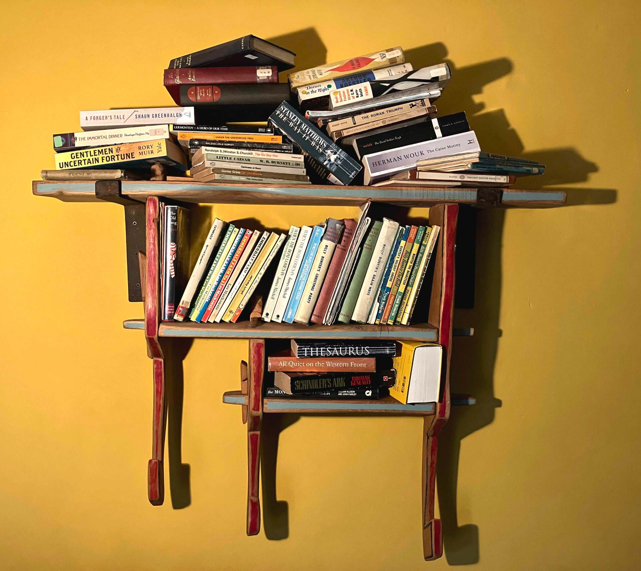 Eco Publishing Scheme for second-hand books: a hand-made wooden book shelf piled up with books