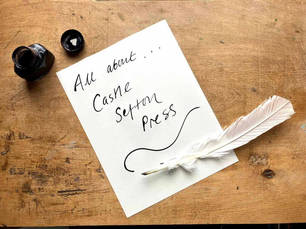 A photograph of a quill pen, ink and writing