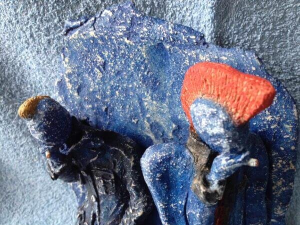 Ceramic sculpture of two punks leaning on a wall smoking.