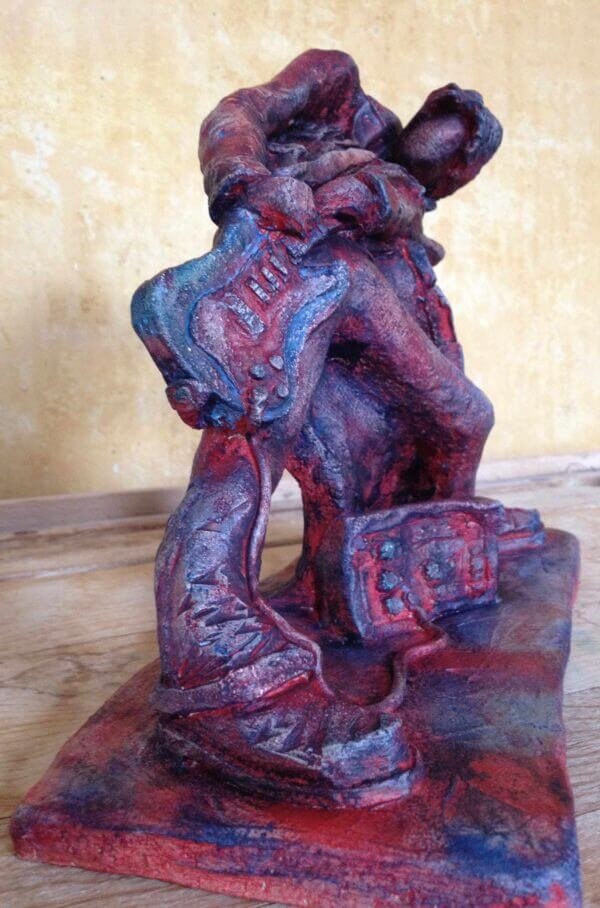 Ceramic sculpture of a rock guitarist painted red