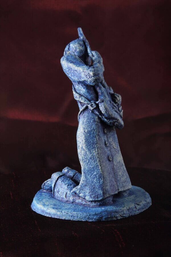 Ceramic sculpture of a kneeling guitarist painted blue.