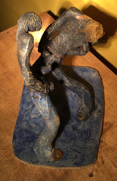 Ceramic sculpture of two air guitarists duelling.