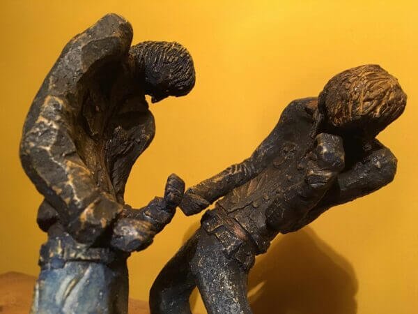 Ceramic sculpture of two air guitarists duelling.