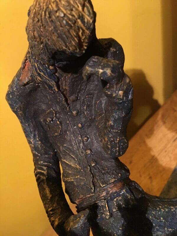 Ceramic sculpture of two air guitarists duelling.