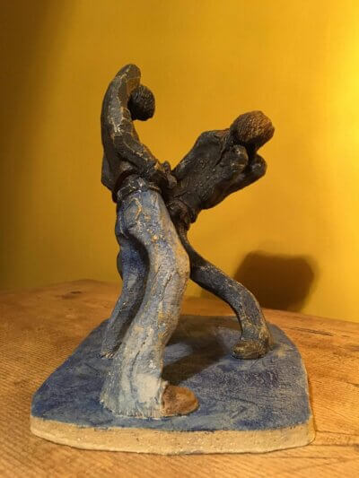 Ceramic sculpture of two air guitarists duelling.