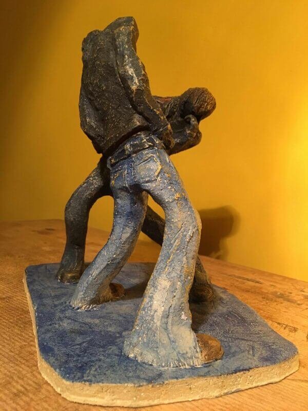 Ceramic sculpture of two air guitarists duelling.