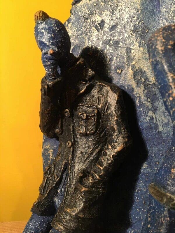 Ceramic sculpture of two punks leaning on a wall smoking.