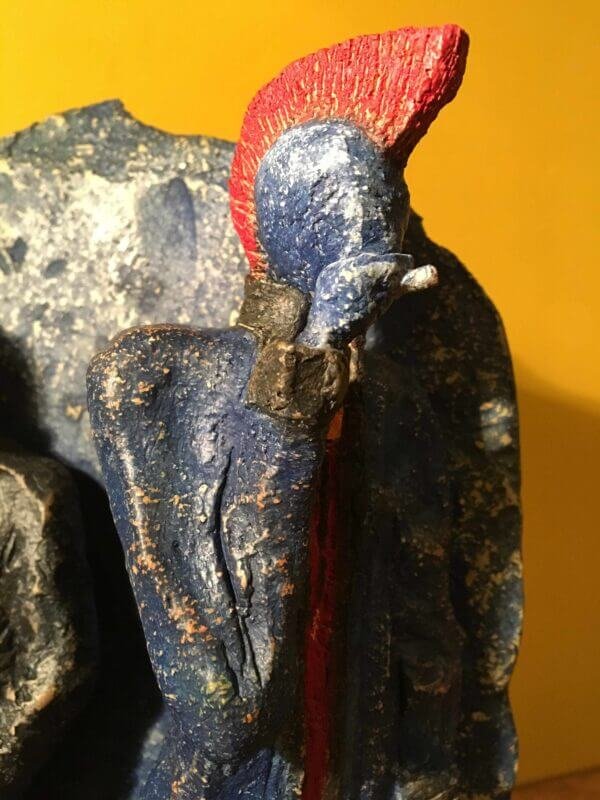 Ceramic sculpture of two punks leaning on a wall smoking.