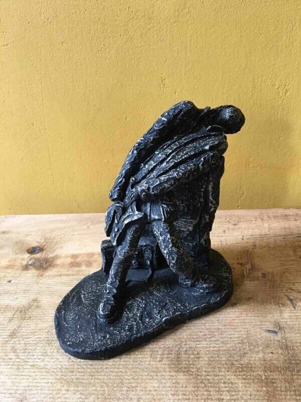 Ceramic sculpture of a rock guitarist painted black.