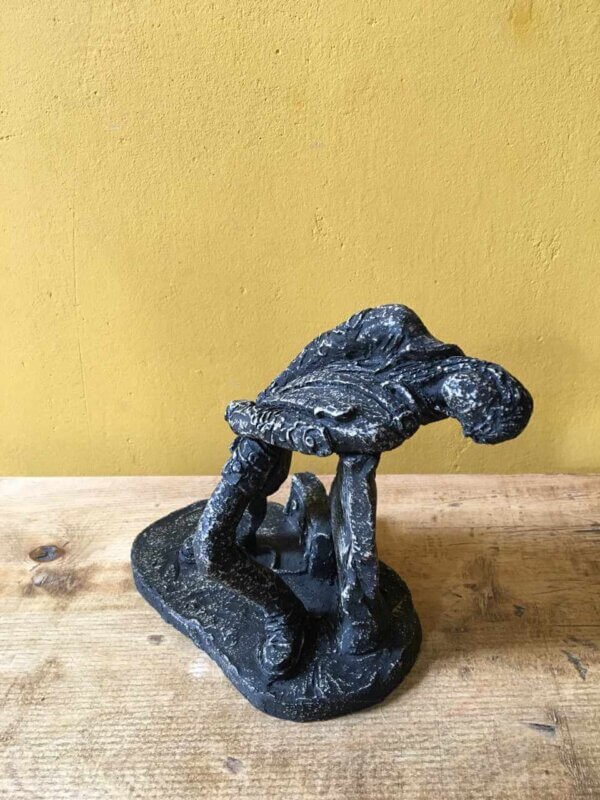 Ceramic sculpture of a rock guitarist painted black.