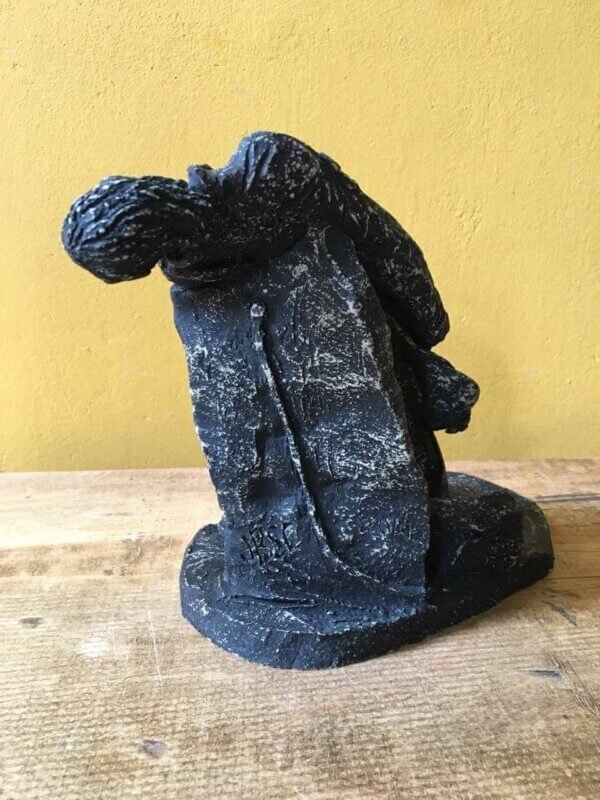 Ceramic sculpture of a rock guitarist painted black.