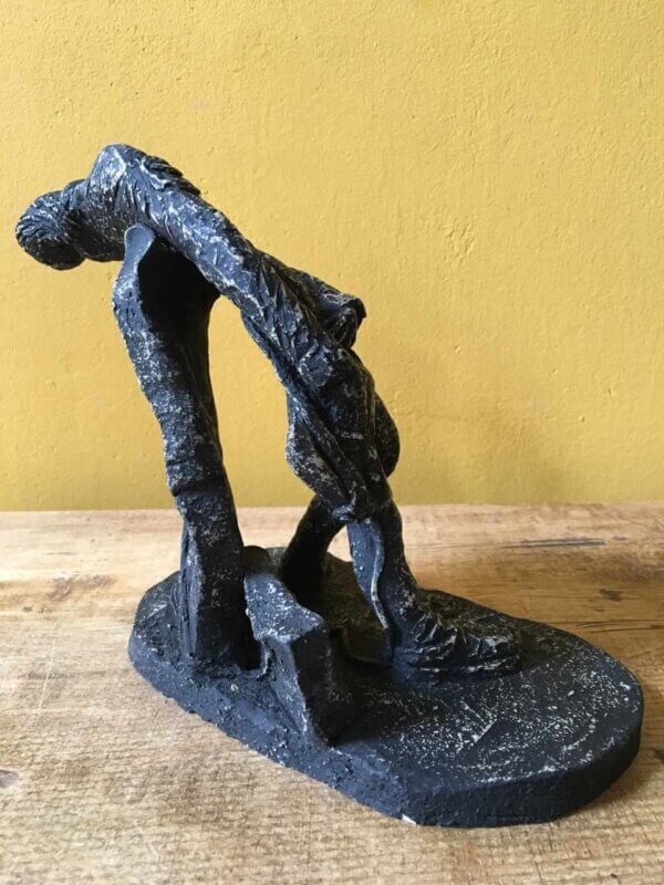 Ceramic sculpture of a rock guitarist painted black.