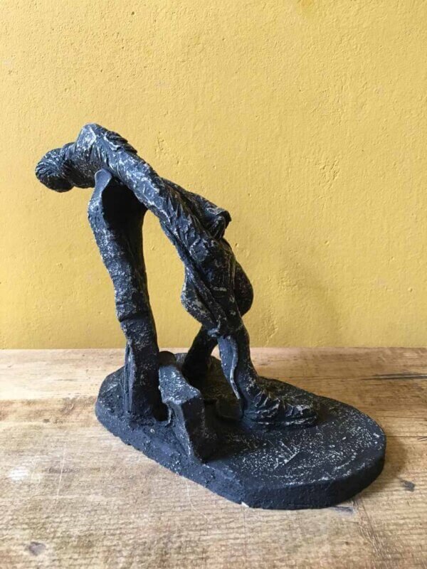 Ceramic sculpture of a rock guitarist painted black.