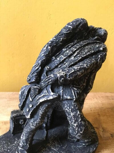 Ceramic sculpture of a rock guitarist painted black.