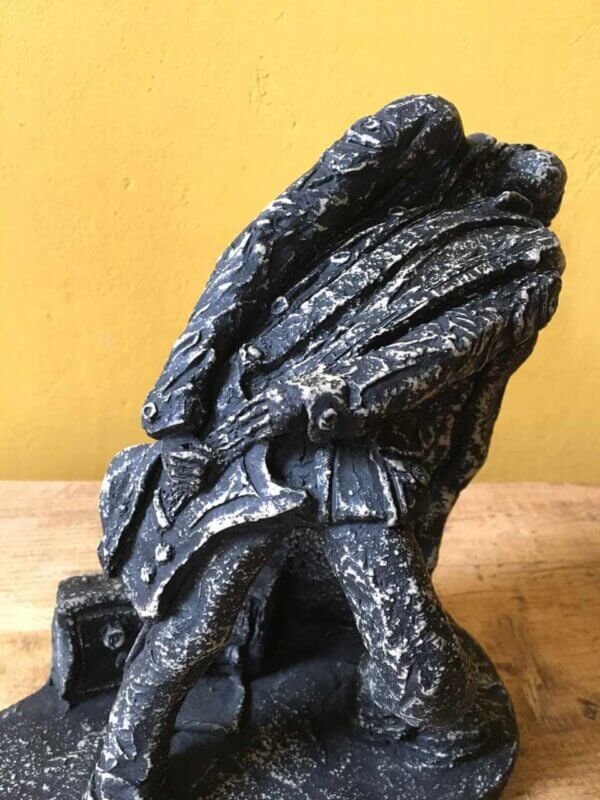 Ceramic sculpture of a rock guitarist painted black.