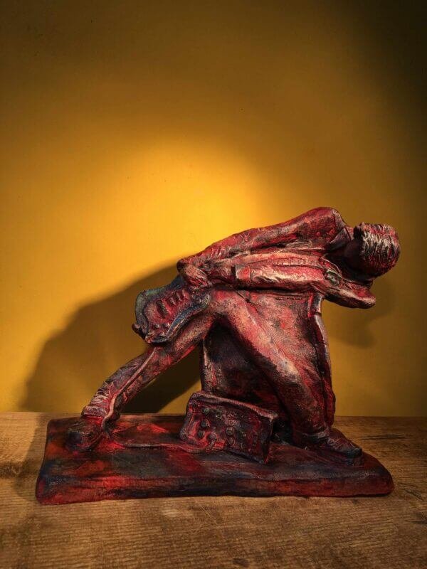 Ceramic sculpture of a rock guitarist painted red