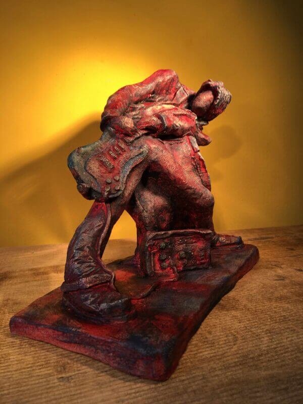Ceramic sculpture of a rock guitarist painted red