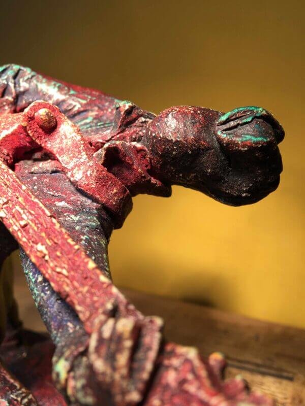 Ceramic sculpture of a rockabilly guitarist painted red.