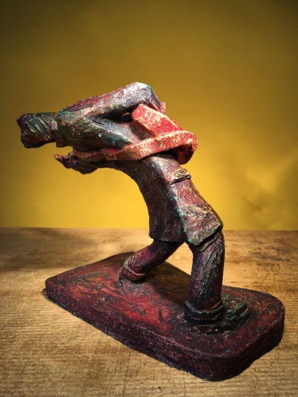 Ceramic sculpture of a rockabilly guitarist painted red.