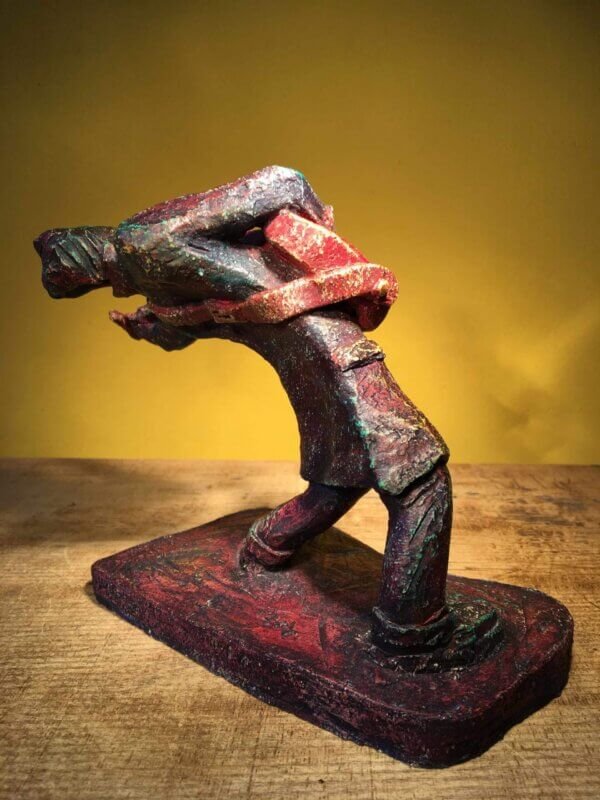 Ceramic sculpture of a rockabilly guitarist painted red.