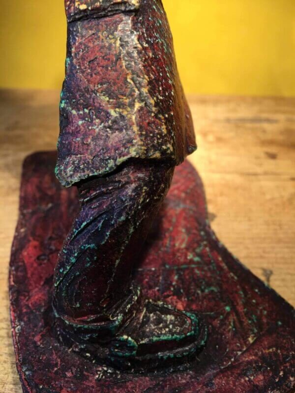 Ceramic sculpture of a rockabilly guitarist painted red.