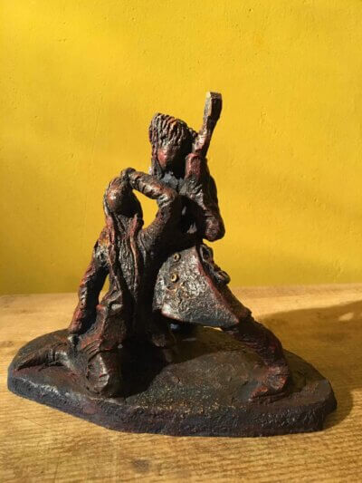 Ceramic sculpture of a singer and guitarist painted red.