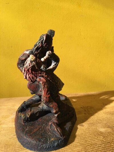Ceramic sculpture of a singer and guitarist painted red.