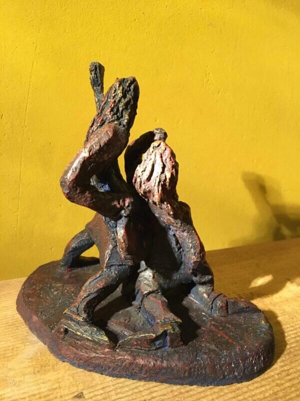 Ceramic sculpture of a singer and guitarist painted red.