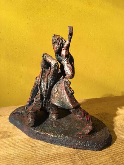 Ceramic sculpture of a singer and guitarist painted red.