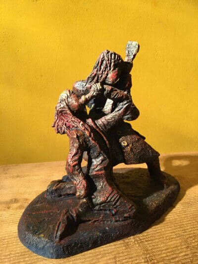 Ceramic sculpture of a singer and guitarist painted red.