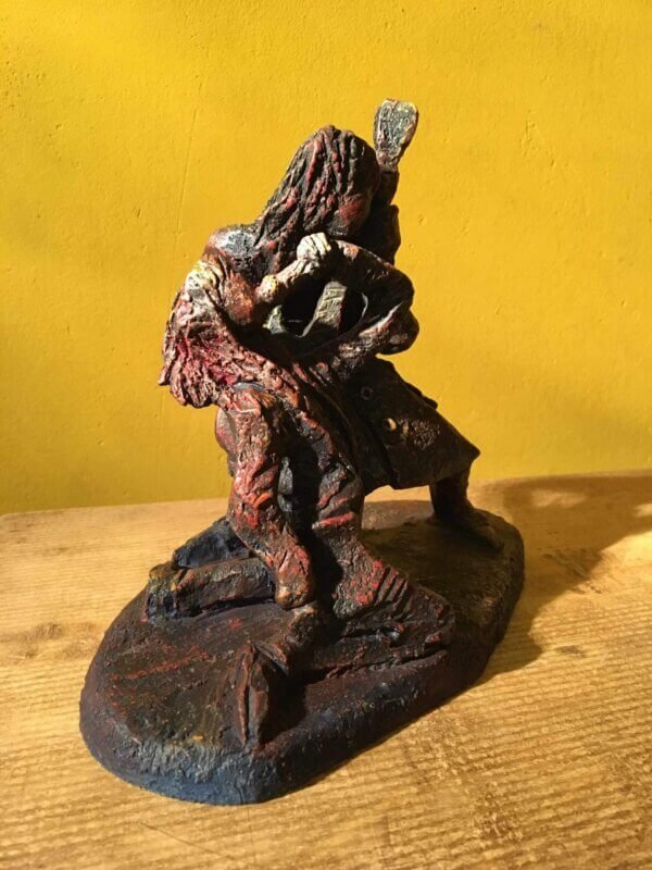 Ceramic sculpture of a singer and guitarist painted red.