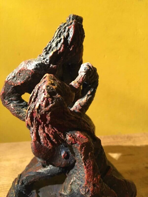 Ceramic sculpture of a singer and guitarist painted red.