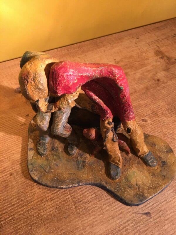 Ceramic sculpture of two figures sitting in hoodies looking at mobile phones with a dog at their feet.