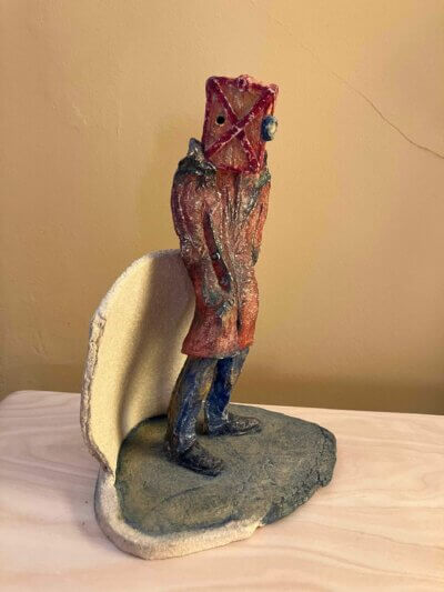 Waiting Room surrealist sculpture of a figure with a box and goggles on its head