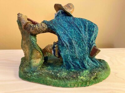 Ceramic sculpture of a Pilgrim Father hunter pointing a gun.