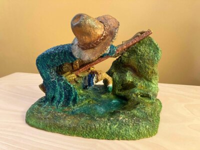 Ceramic sculpture of a Pilgrim Father hunter pointing a gun.