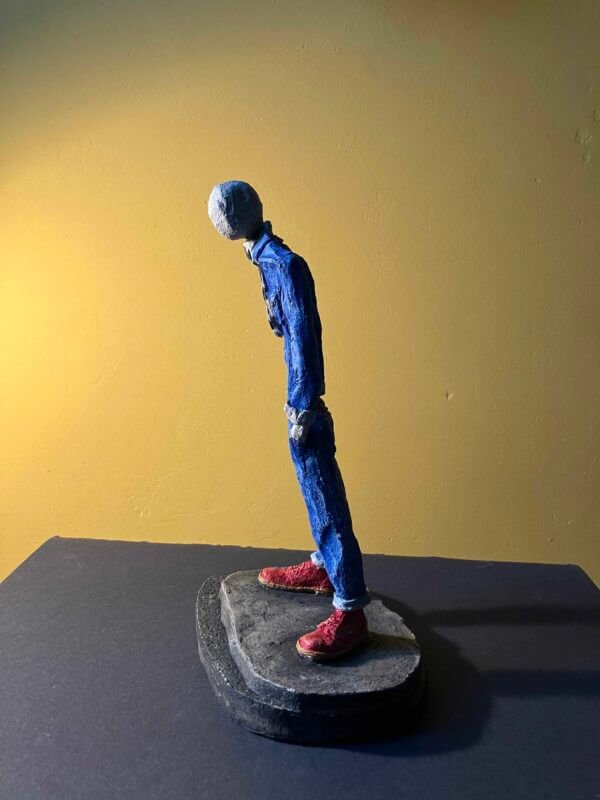 Ceramic sculpture of a skinhead in a black-and-white scarf