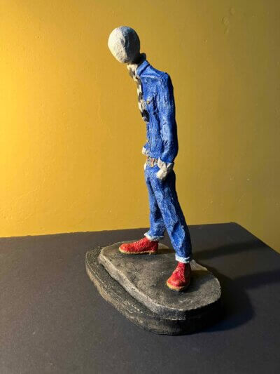 Ceramic sculpture of a skinhead in a black-and-white scarf