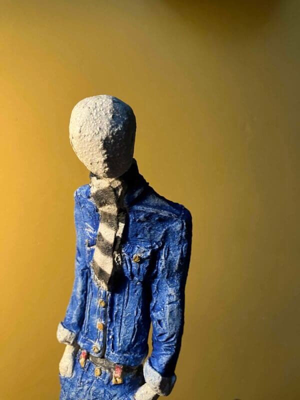 Ceramic sculpture of a skinhead in a black-and-white scarf