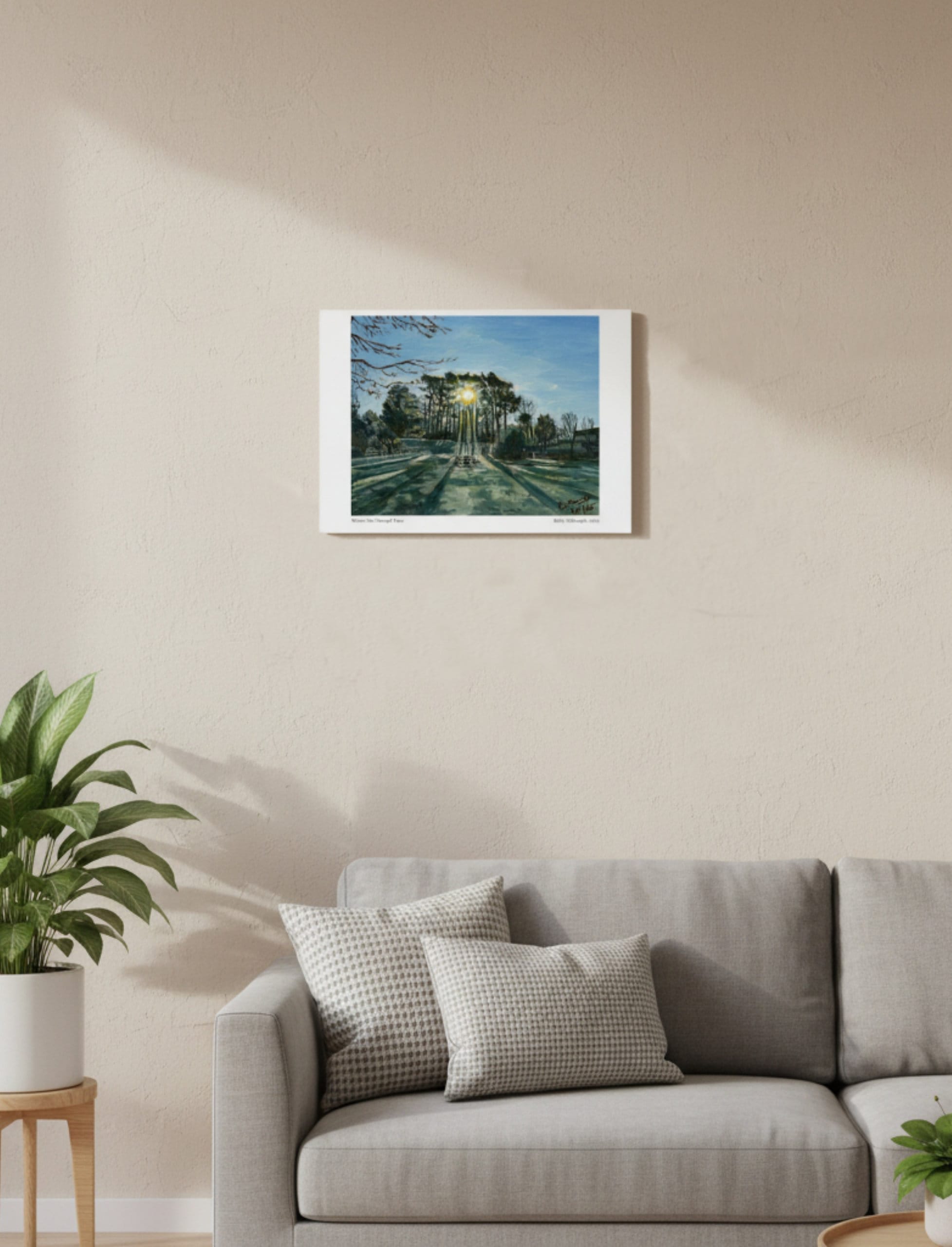 Winter Sun Through Trees Art Print shown on a cream wall above a beige couch