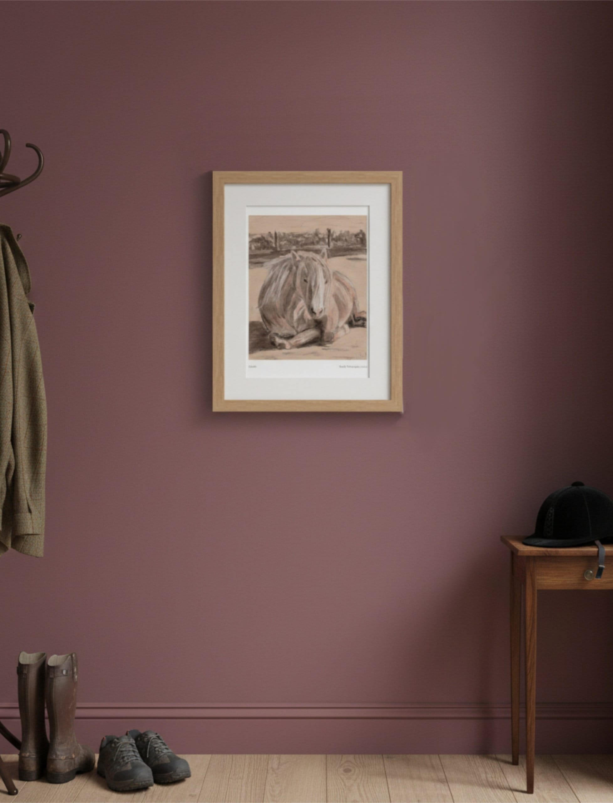 Goldie the Palomino Framed Art Print on dark red walls next to a coat stand and riding hat