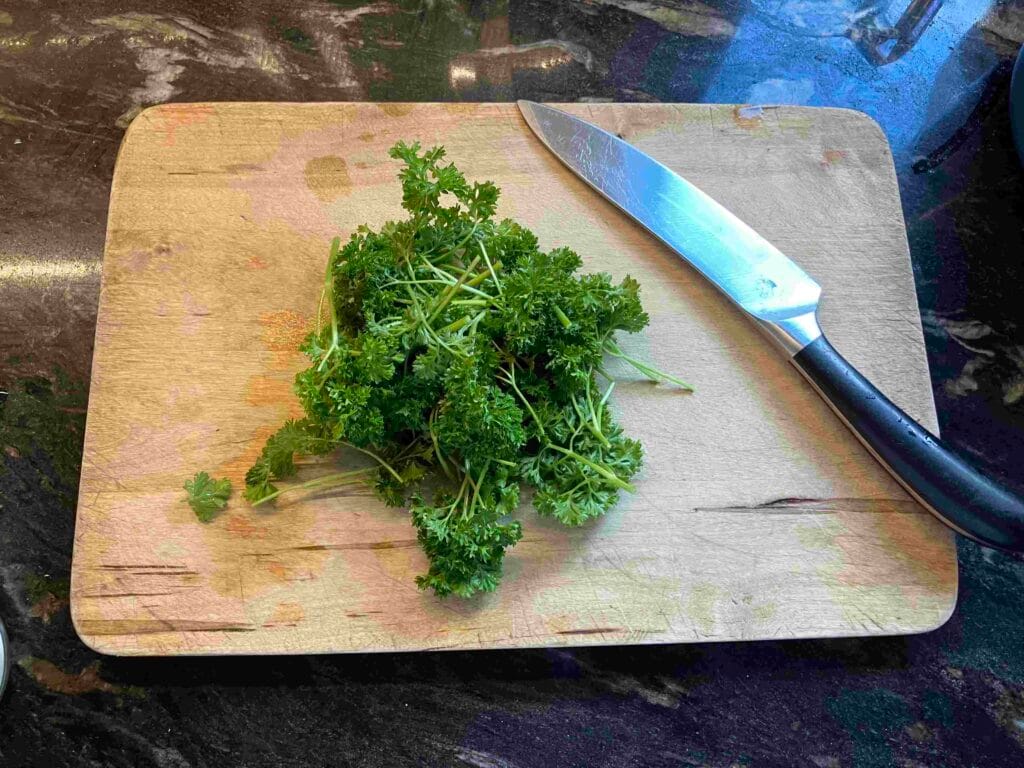 Parsley ona chopping board with a knife