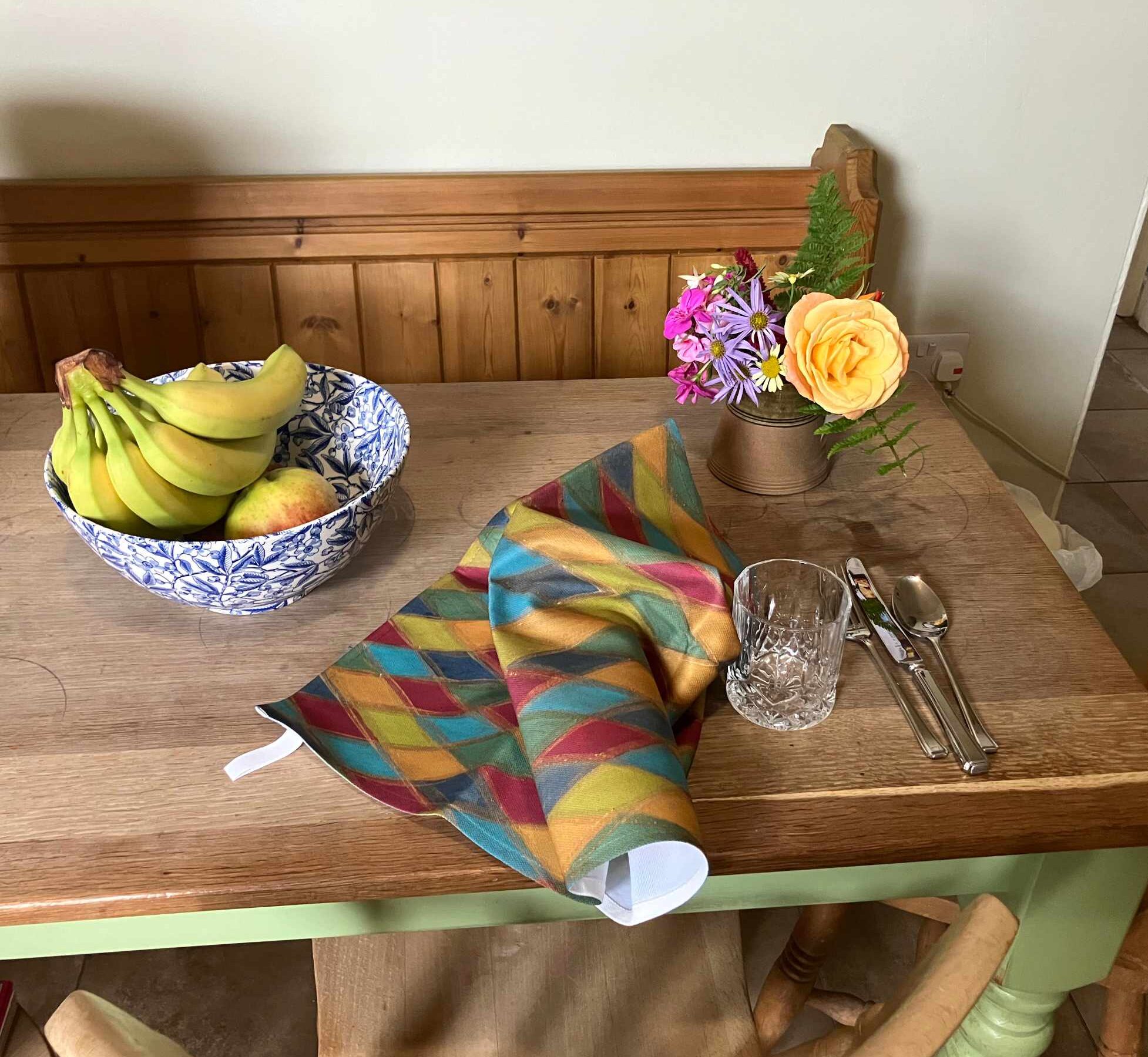From our Homeware and Accessories collection: Harlequin Teatowel on a table with flowers and fruit